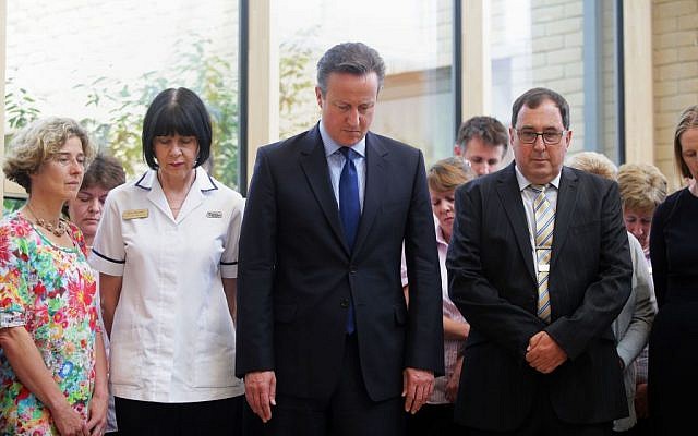 Britain's Prime Minister, David Cameron, centre, stands in silence during a visit to Chipping Norton Health Centre in his constituency in Witney, England, as Britain remembers the victims of the Tunisia terror attack with a minute's silence, Friday, July 3, 2015. (Daniel Leal-Olivas/PA via AP) Britain's Prime Minister, David Cameron, centre, stands in silence during a visit to Chipping Norton Health Centre in his constituency in Witney, England, as Britain remembers the victims of the Tunisia terror attack with a minute's silence, Friday, July 3, 2015. (Daniel Leal-Olivas/PA via AP)