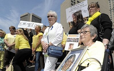 Pat Steinhelper, right, 77, of Waterford, holds a picture of her husband, Jerry Steinhelper, who died due to complications of chemotherapy at the hands of Dr. Fata. (Todd McInturf/Detroit News via AP)