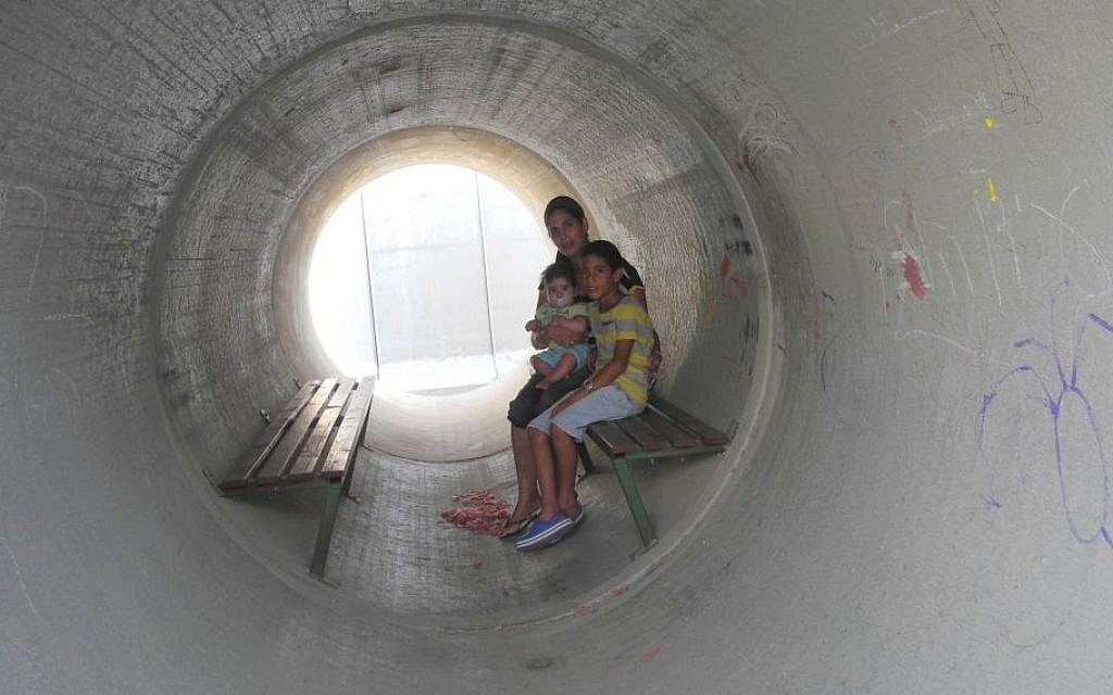 Devorah Israeli, of Nitzan, with 8-year-old Idan and 6-month-old Ron in the sewage pipe bomb shelter next to her caravilla during Operation Protective Edge in summer 2014. (Melanie Lidman/Times of Israel)