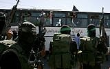 Hamas members watch as a bus carrying Palestinian prisoners arrives at the Rafah crossing with Egypt in the southern Gaza Strip as part of the deal for the release of hostage Gilad Shalit on October 18, 2011. (Abed Rahim Khatib/Flash 90)