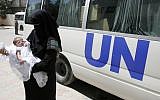 A Palestinian woman holds her baby in an UNRWA center in the Rafah refugee camp, in southern Gaza Strip on August 13, 2014. (Abed Rahim Khatib/Flash90)