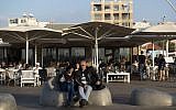 An Israeli couple sits at the Tel Aviv port boardwalk on November 15, 2014. (Danielle Shitrit/Flash90)