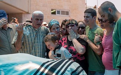 The family of Malachy Moshe Rosenfeld mourns near his body during his funeral at Kochav Hashahar in West Bank, July 01, 2015. (Yonatan Sindel/FLASH90)
