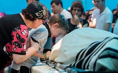 The family of Malachy Moshe Rosenfeld mourn near his body during his funeral at Kohav Hashahar in the West Bank, July 1, 2015. (Yonatan Sindel/FLASH90)