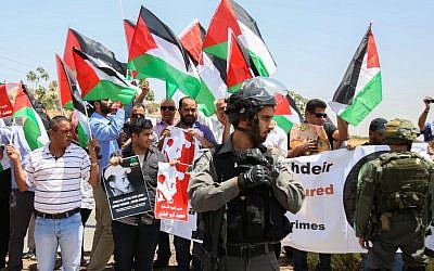 Palestinian protesters block a road leading to the Adam settlement in the West Bank, during a demonstration to mark the first anniversary of the killing of 16-year-old Palestinian Mohammed Abu Khder, July 2, 2015. (Flash90)
