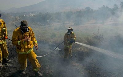 Firefighters trying to extinguish a large fire that broke out near Kiryat Shmona, July 19, 2015, causing residents in the area to evacuate their homes. (Basel Awidat/Flash90)