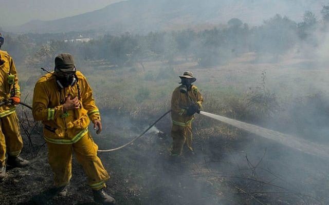 Firefighters trying to extinguish a large fire that broke out near Kiryat Shmona, July 19, 2015, causing residents in the area to evacuate their homes. (Basel Awidat/Flash90)
