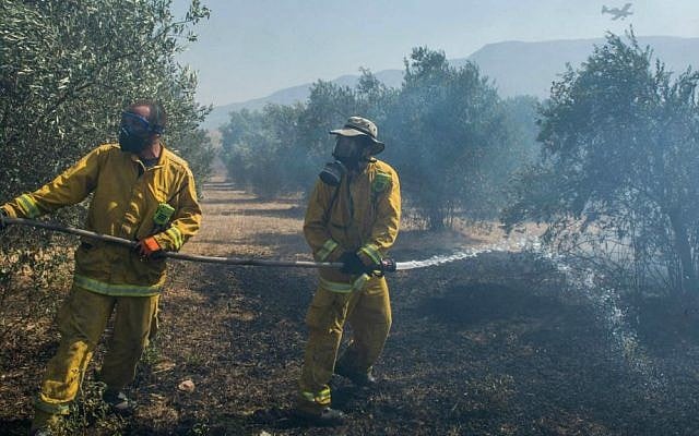Firefighters trying to extinguish a large fire that broke out near Kiryat Shmona, July 19, 2015, causing residents in the area to evacuate their homes. (Basel Awidat/Flash90)