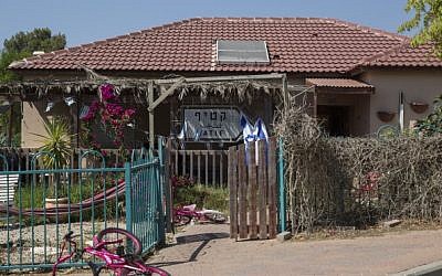 A caravilla temporary housing unit has a sign pointing to the settlement of Katif, taken from the original settlement in the Gush Katif settlements in Gaza. This caravilla is part of the Karmei Katif temporary neighborhood, another Gush Katif town that has been awaiting permanent housing for a decade. (Hadas Parush/Flash90)
