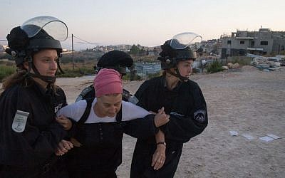 Israeli security forces drag away a Jewish settler who came to demonstrate an evacuation at the Jewish settlement of Beit El, near the West Bank town of Ramallah, July 28, 2015 (Nati Shohat/FLASH90)