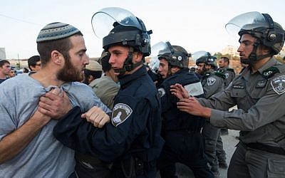 Israeli security forces scuffle with settlers who had barricaded themselves in an attempt to prevent the demolition of illegally constructed buildings, at the Jewish settlement of Beit El, near the West Bank town of Ramallah, on July 28, 2015 (Nati Shohat/FLASH90)