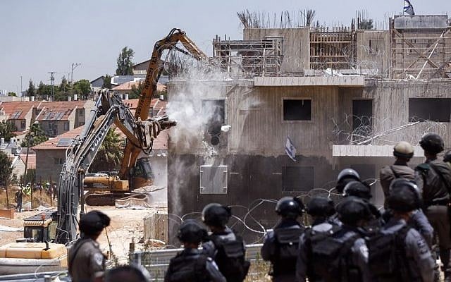 Pictured: Israeli security forces watching as a tractor begins to demolish two buildings in the Israeli settlement of Beit El, near the West Bank city of Ramallah, July 29, 2015. (Yonatan Sindel/FLASH90)demolish two buildings in the Israeli settlement of Beit El, near the West Bank city of Ramallah, July 29, 2015. (Yonatan Sindel/FLASH90) Pictured: Israeli security forces watching as a tractor begins to demolish two buildings in the Israeli settlement of Beit El, near the West Bank city of Ramallah, July 29, 2015. (Yonatan Sindel/FLASH90)demolish two buildings in the Israeli settlement of Beit El, near the West Bank city of Ramallah, July 29, 2015. (Yonatan Sindel/FLASH90)