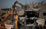 A bulldozer demolishes two buildings in the settlement of Beit El on July 29, 2015 (Photo by Yonatan Sindel/Flash90)