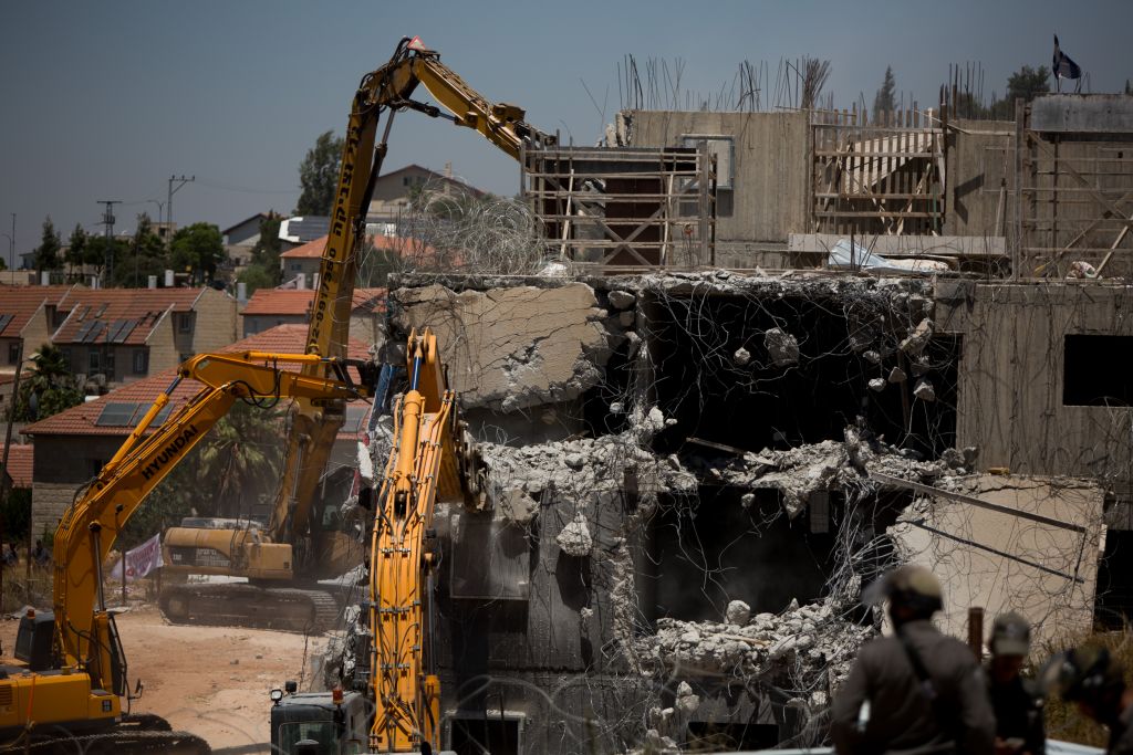 A bulldozer demolishes two buildings in the settlement of Beit El on July 29, 2015 (Photo by Yonatan Sindel/Flash90) A bulldozer demolishes two buildings in the settlement of Beit El on July 29, 2015 (Photo by Yonatan Sindel/Flash90)