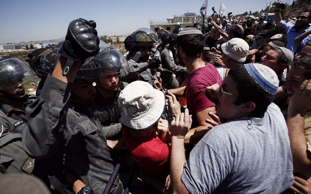 Israeli security forces scuffle with Jewish settlers in the Israeli settlement of Beit El, near the West Bank city of Ramallah, following the High Court's decision to uphold an earlier order to demolish two buildings in the settlement, on July 29, 2015. (Yonatan Sindel/FLASH90)