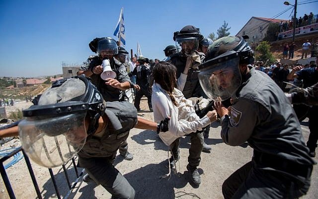 Israeli security forces scuffle with Jewish settlers in the Israeli settlement of Beit El, near the West Bank city of Ramallah, on July 29, 2015, following the High Court's decision to upheld an earlier order to demolish two buildings in the settlement. (Yonatan Sindel/Flash90)