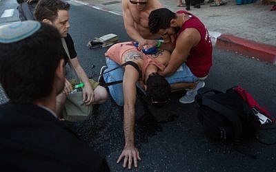 People tend to a young Israeli wounded in a stabbing attack while participating in the annual pride parade in Jerusalem on July 30, 2015 (Miriam Alster/Flash90)