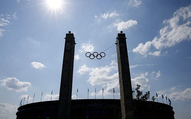 In this June 6, 2015 file photo the Olympic Rings are silhoetted outside the Olympic stadium in Berlin ahead of the Champions League final soccer match between Juventus Turin and FC Barcelona. (AP Photo/Luca Bruno, file)
