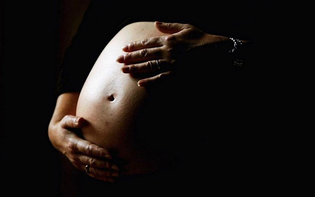 A pregnant woman holding her stomach: Egg banks report that they cannot meet the demand for Jewish donations. (Ian Waldie/Getty Images/via JTA) A pregnant woman holding her stomach: Egg banks report that they cannot meet the demand for Jewish donations. (Ian Waldie/Getty Images/via JTA)