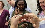 Dror Tamir offers one of Steak TzarTzar's edible grasshoppers to potential tasters. The company was one of the Israeli start-ups at FoodTech Nation, December 15, 2015 (Courtesy)