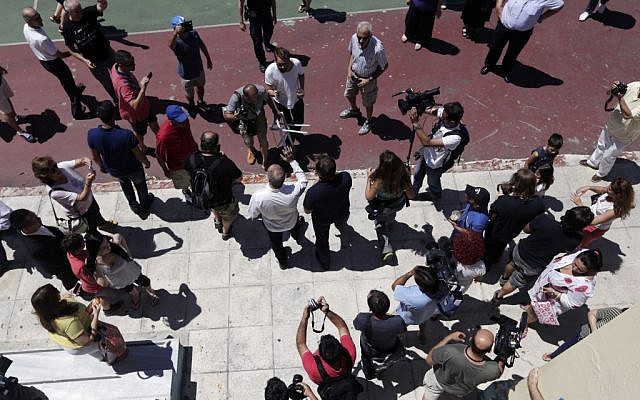 Greece's Finance Minister Yanis Varoufakis, center, waves to his supporters after voting at a polling station in Athens, Sunday, July 5, 2015. (AP /Petr David Josek) 