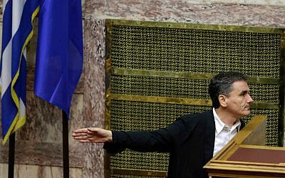 Greece's Finance Minister Euclid Tsakalotos gestures as he speaks with a lawmaker during an emergency parliament session in Athens, Wednesday, July 22, 2015. (AP Photo/Thanassis Stavrakis)