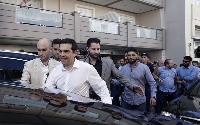 Greece's Prime Minister Alexis Tsipras, foreground, is escorted by police officers after voting in Greece's debt referendum at a polling station in Athens, Sunday, July 5, 2015. (AP/Petros Giannakouris) Greece's Prime Minister Alexis Tsipras, foreground, is escorted by police officers after voting in Greece's debt referendum at a polling station in Athens, Sunday, July 5, 2015. (AP/Petros Giannakouris)