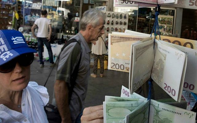 A woman wearing a hat in the colors of Greece's national flag, looks at wallets designed as Euro banknotes on display, outside a kiosk in central Athens, Tuesday, July 14, 2015. (AP Photo/Petros Giannakouris) A woman wearing a hat in the colors of Greece's national flag, looks at wallets designed as Euro banknotes on display, outside a kiosk in central Athens, Tuesday, July 14, 2015. (AP Photo/Petros Giannakouris)