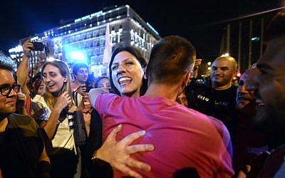Greek parliament's president and Syriza party member, Zoe Kostantopoulou  (C)  embraces a 'NO' supporter , as she joins the celebrations in  front of the parliament latein Athens on July 5, 2015. Greece's Prime Minister Alexis Tsipras said that the 'No' victory in the country's bailout referendum did not mean Athens was headed for a so-called Grexit. AFP PHOTO / Louisa Gouliamaki