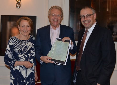 Jerry Springer (center) with his parents' documents, with Linda Rosenblatt, World Jewish Relief vice chair and James Libson, World Jewish Relief chair (Courtesy World Jewish Relief)