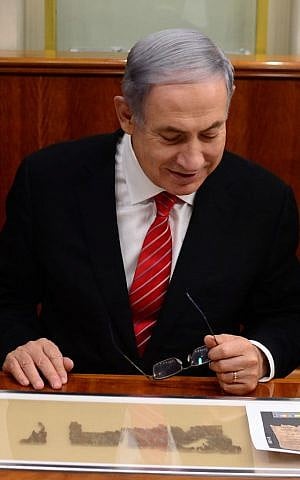 Benjamin Netanyahu examining a 2,000-year-old scroll fragment from the Book of Lamentations. (Kobi Gideon, GPO)