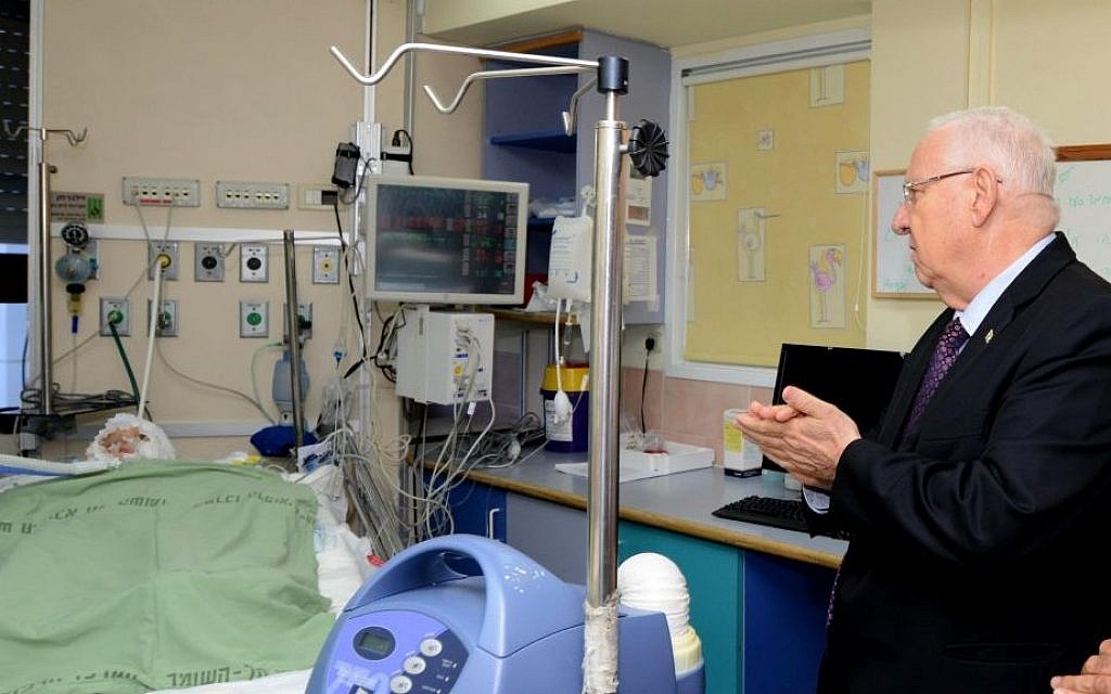 File: President Reuven Rivlin visits Ahmad Dawabsha on Friday, July 31, 2015. Dawabsha was badly burned after Jewish terrorists burned the house in which he lived in the village of Duma, near Nablus in the West Bank. (Mark Neyman/GPO)