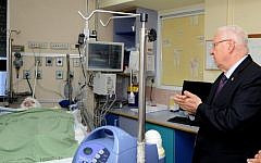 File: President Reuven Rivlin visits Ahmad Dawabsha on Friday, July 31, 2015. Dawabsha was badly burned after Jewish terrorists burned the house in which he lived in the village of Duma, near Nablus in the West Bank. (Mark Neyman/GPO)