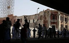 Egyptian policemen stand at the base of the crumbled facade of the Italian consulate following a blast that killed at least one person in Cairo, Egypt, Saturday, July 11, 2015 (Hassan Ammar/AP)