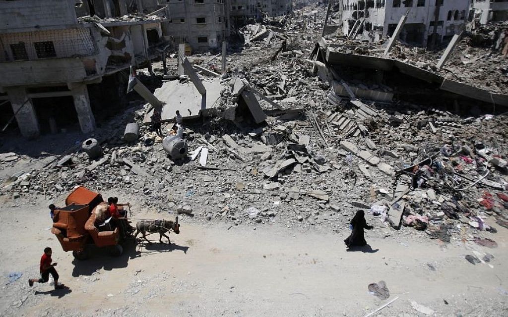In this August 1, 2014, file photo, Palestinians carry their belongings through the heavily bombed Gaza City neighborhood of Shujaiyah, close to the Israeli border. (AP/Hatem Moussa) In this August 1, 2014, file photo, Palestinians carry their belongings through the heavily bombed Gaza City neighborhood of Shujaiyah, close to the Israeli border. (AP/Hatem Moussa)