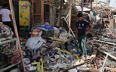 Civilians gather at the scene of a suicide car bombing at a busy market in Khan Bani Saad in the Diyala province, about 20 miles (30 kilometers) northeast of Baghdad, Iraq, Saturday, July 18, 2015. (AP/Karim Kadim)