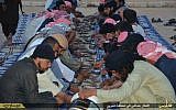 In this photo provided by a website of the Islamic State group, Muslims eat their meals distributed by the IS group as they break their fast during the holy month of Ramadan in the northern Syrian province of Aleppo, June 20, 2015. (Islamic State militant via AP)