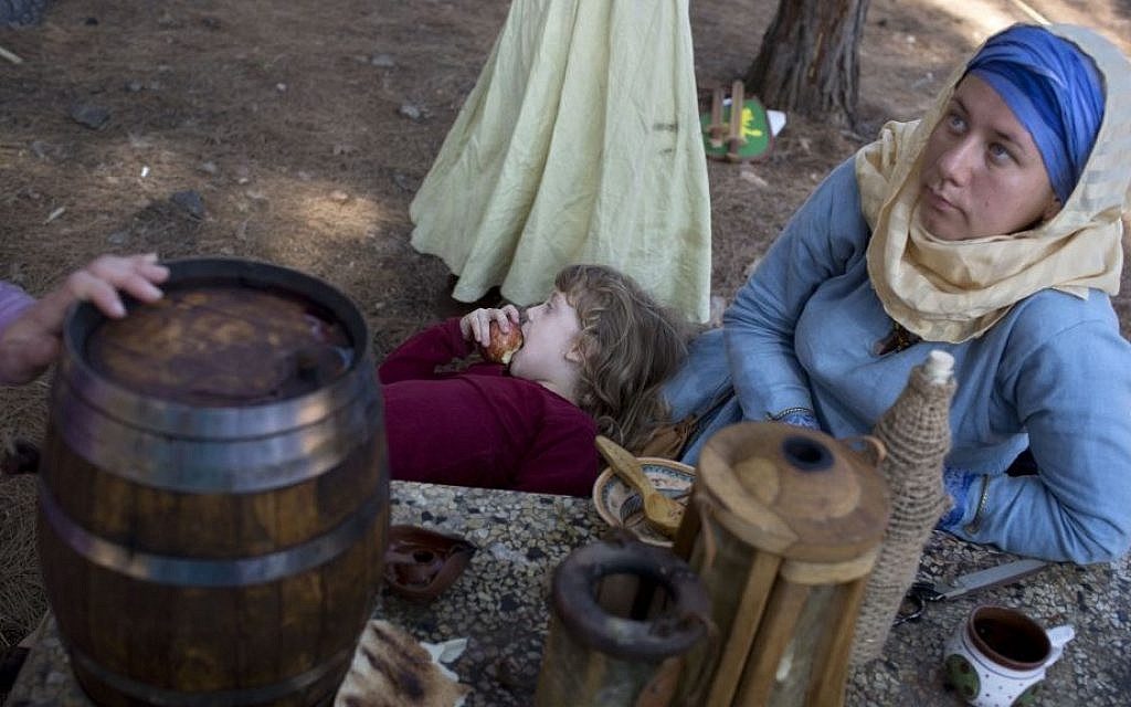 Israeli and Russian members of knight clubs wearing medieval costumes have breakfast before the reenactment of the Battle of Hattin in Lavi Forest, northern Israel, July 4, 2015. (AP/Oded Balilty)