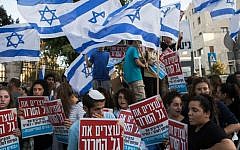 Israelis hold signs and wave flags during a demonstration outside the prime minister's residence in Jerusalem on Wednesday, July 1, 2015, calling on Prime Minister Benjamin Netanyahu to act against recent Palestinian attacks against Israelis. (AP Photo/Dan Balilty)