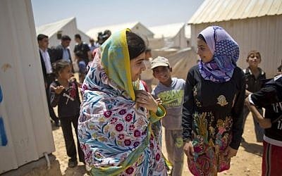 Nobel Peace Prize laureate Malala Yousafzai, 18 (left), walks with Mezon al-Melihan, a 17-year-old refugee from the southern Syrian town of Deraa, during Malala's visit to the Azraq refugee camp in Jordan, July 13, 2015. (AP/Muhammed Muheisen)