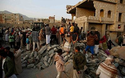 People search for survivors under the rubble of houses destroyed by Saudi airstrikes in Sanaa, Yemen, Monday, July 13, 2015. (AP Photo/Hani Mohammed)