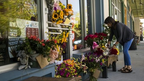 A woman leaves a bouquet of flowers at a makeshift memorial for store co-owner Jillian Johnson at Red Arrow Workshop in River Ranch in Lafayette, La., Friday, July 24, 2015 (Paul Kieu/The Daily Advertiser via AP) A woman leaves a bouquet of flowers at a makeshift memorial for store co-owner Jillian Johnson at Red Arrow Workshop in River Ranch in Lafayette, La., Friday, July 24, 2015 (Paul Kieu/The Daily Advertiser via AP)