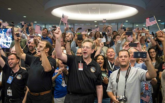 Jim Green, NASA Planetary Science Division director, center, and other New Horizons team members count down to the spacecraft's closest approach to Pluto, Tuesday, July 14, 2015 at the Johns Hopkins University Applied Physics Laboratory (APL) in Laurel, Maryland. (Bill Ingalls/NASA via AP)