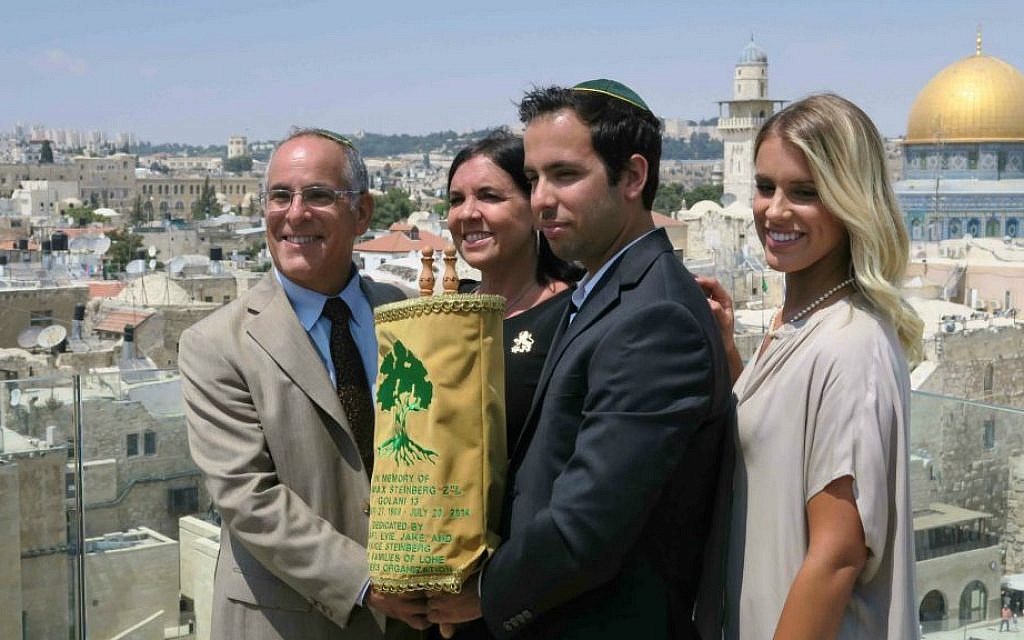 From left: Stuart, Evie, Jake, and Paige Steinberg on July 12 with a Torah scroll, adorned with Golani colors and symbol, written in honor of Sgt. Max Steinberg (Luke Tress/ Times of Israel) From left: Stuart, Evie, Jake, and Paige Steinberg on July 12 with a Torah scroll, adorned with Golani colors and symbol, written in honor of Sgt. Max Steinberg (Luke Tress/ Times of Israel)