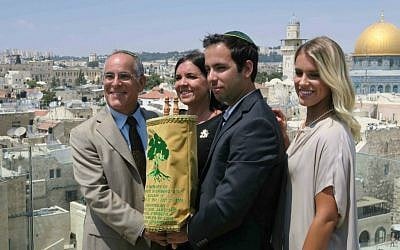 From left: Stuart, Evie, Jake, and Paige Steinberg on July 12 with a Torah scroll, adorned with Golani colors and symbol, written in honor of Sgt. Max Steinberg (Luke Tress/ Times of Israel)