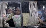 In this Dec. 20, 2012, file photo, Syrian refugees, who fled their home in Idlib due to a government airstrike, look out of a vehicle's window just after crossing the border from Syria to Turkey in Cilvegozu, Turkey. (AP Photo/Muhammed Muheisen, File)