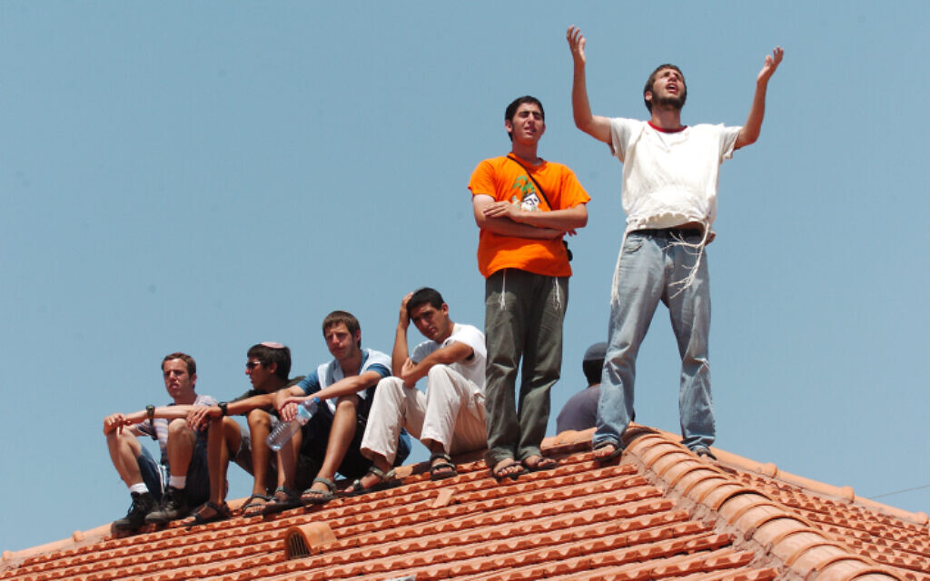 Settlers cry and pray on a roof in the former Gaza settlement of Neve Dekalim as Israel carries out the Disengagement Plan, August 17, 2005. (Nati Shohat/Flash90)