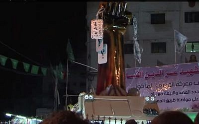 A model fist holds 3 mock Israeli army dog tags at a Hamas rally in Gaza, July 8, 2015 (YouTube screenshot)