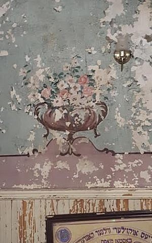 A dilapidated mural in the study hall of Boston’s so-called Vilna Shul, as photographed on July 17, 2015. In the weeks ahead, the mural will be restored by volunteers using mosaic tiles, according to Barnet Kessel, head of Boston’s Center for Jewish Culture. The urn with flowers was originally painted during the Great Depression, not long after the building construction in 1919, noted Kessel. (photo credit: Matt Lebovic/The Times of Israel). A dilapidated mural in the study hall of Boston’s so-called Vilna Shul, as photographed on July 17, 2015. In the weeks ahead, the mural will be restored by volunteers using mosaic tiles, according to Barnet Kessel, head of Boston’s Center for Jewish Culture. The urn with flowers was originally painted during the Great Depression, not long after the building construction in 1919, noted Kessel. (photo credit: Matt Lebovic/The Times of Israel).