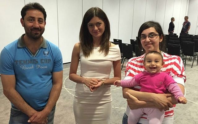 A young Christian Syrian couple with their seven month old daughter flank Miriam Shaded, a Polish church charity worker, who will help the families resettle in Poland, in Warsaw last week. Shaded has a Syrian Christian background and works for the Esther Foundation. (courtesy)